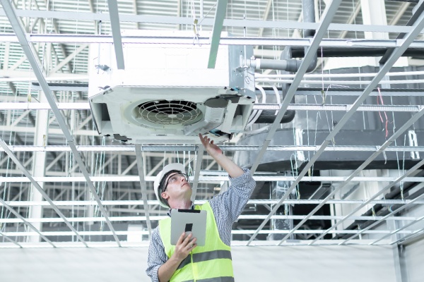 Man inspecting an HVAC unit.