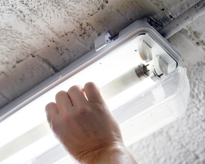 Person installing a new light bulb